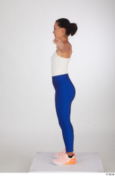 Premium Photo  A woman in a white top and blue leggings stands in